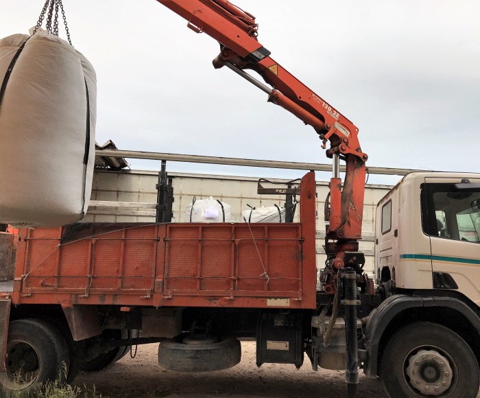 Truck loading carriers bags of olive leaves